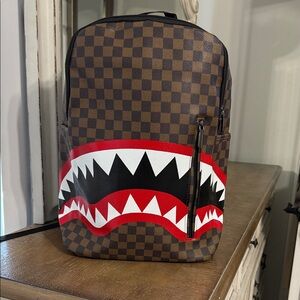 Brown Checkered Backpack with Red and Black Design